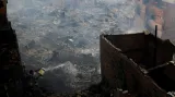 Obyvatel slumu Paraisopolis (Rajské město) se pokouší z okna svého domu pomocí kýblů s vodou uhasit rozsáhlý požár v chudinské čtvrti brazilského Sao Paola.