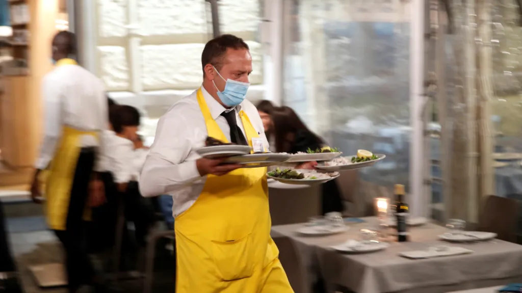 Číšník v roušce v italské restauraci