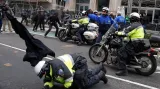 Policisté při zajišťování bezpečnosti během inauguračního ceremoniálu. Jeden padá z motorky, druhý stříká pepřový sprej po demonstrantech.