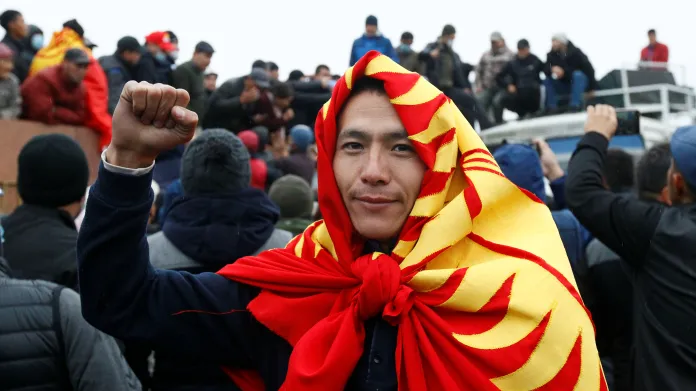 Jeden z protestujících s uvázanou kyrgyzskou vlajkou kolem krku