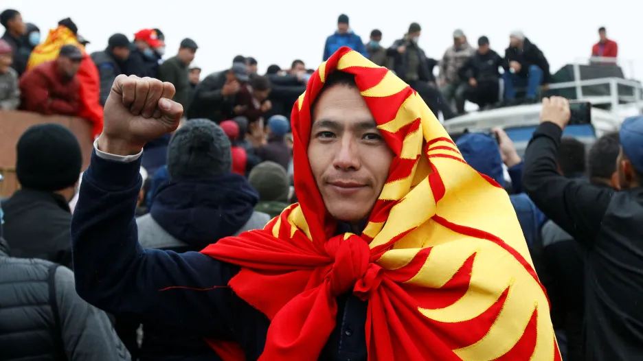 Jeden z protestujících s uvázanou kyrgyzskou vlajkou kolem krku