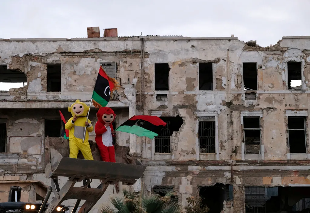 Chlapci v kostýmech a s libyjskou vlajkou oslavují v Benghází osmé výročí revoluce