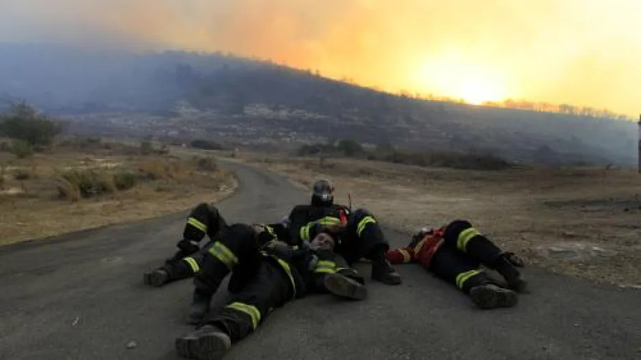 Izraelští hasiči odpočívají po nočním hašení požáru u Haify