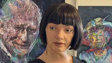 Ai-Da před portréty Alžběty II. a Karla III.