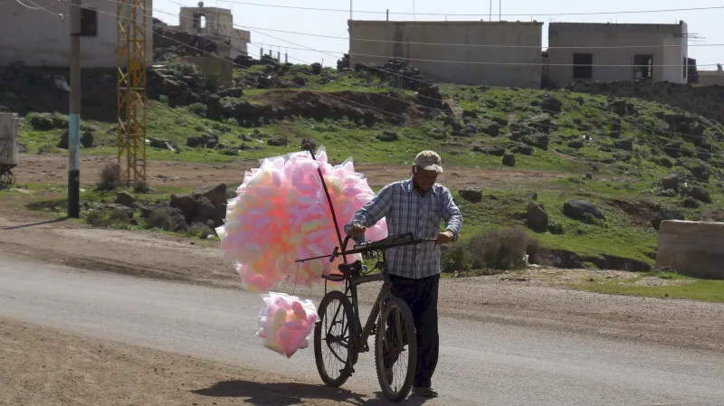 Prodejce cukrové vaty ve zničeném městě al-Ghariyah v provincii Deraa