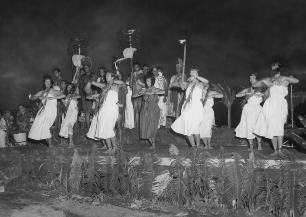 Skupina lidí v tradičních havajských krojích předvádí návštěvníkům tanec v Národním parku Hawaii Volcanoes, na Havaji v roce 1957
