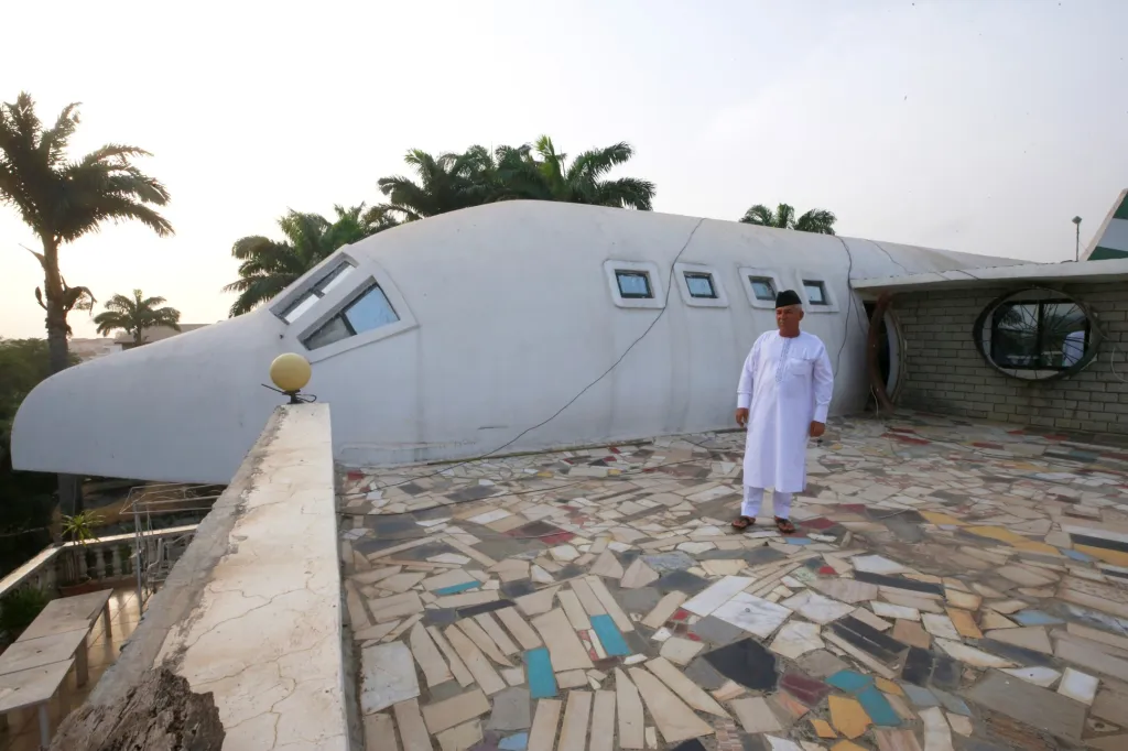 Said Jammal stojí vedle domu ve tvaru letadla, který si postavil v městské čtvrti Abuja v Nigérii