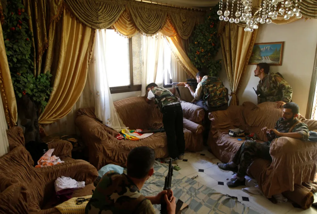 Provládní syrští bojovníci si z jednoho bytu v Aleppu udělali bojovou základnu pro odstřelovače. Snímek pořízený 14. srpna 2012