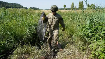 Litevský voják nese žiletkový ostnatý drát