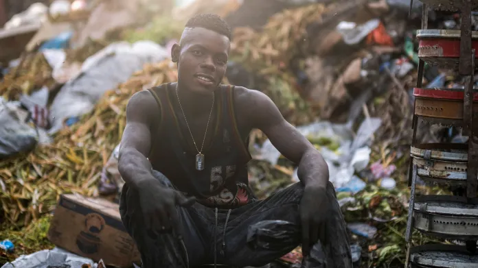 Mladík prodává na ulici v Port-au-Prince dřevěné uhlí