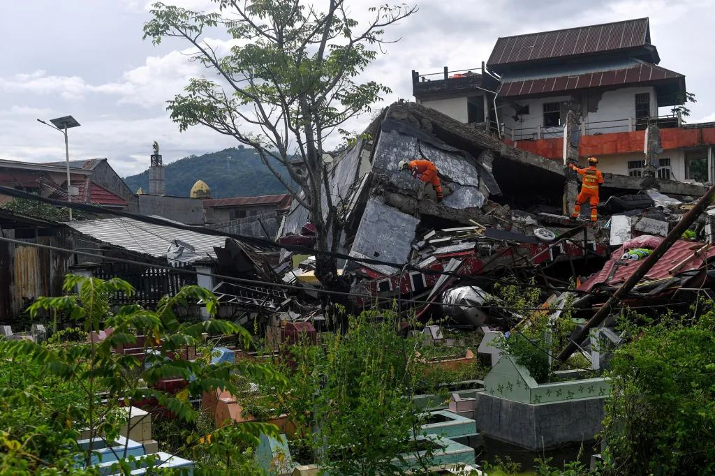 Záchranáři prohledávají zřícenou budovu, která spadla v důsledku zemětřesení v Mamuju, v provincii Západní Sulawesi v Indonésii