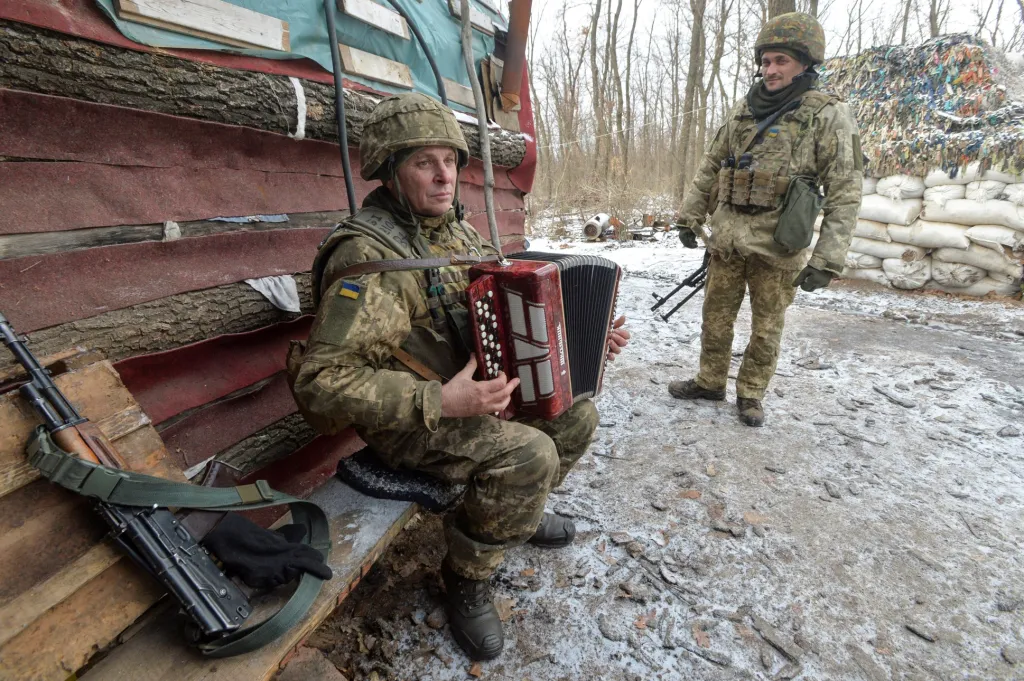 Situace na ukrajinsko-ruské hranici je stále napjatá. Přesto si vojáci snaží občas zpříjemnit službu přímo na bojových pozicích. Na snímku člen ukrajinské armády hraje na harmoniku u města Avdijivka v Doněcké oblasti