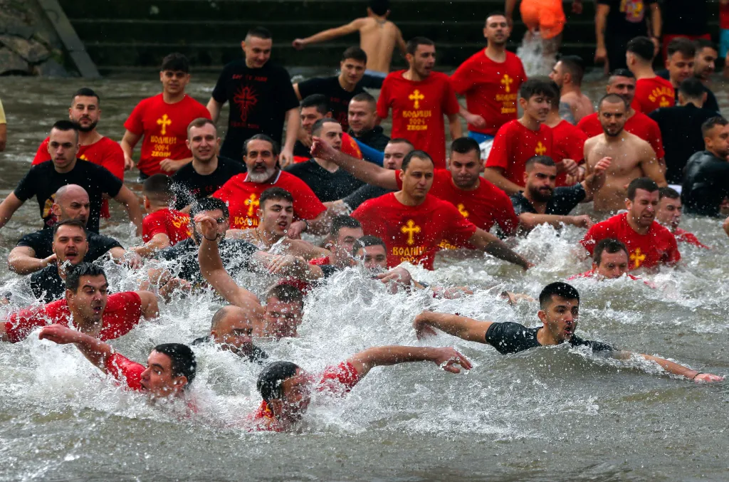 Pravoslavní křesťané ve Skopji se snaží chytit dřevěného kříže, který do vody hodil kněz