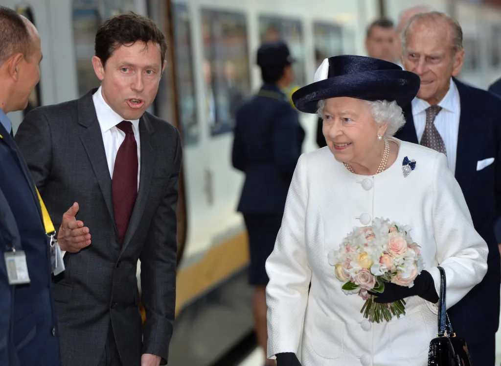 Britská královna Alžběta II. a princ Philip jsou představeni členům personálu generálním ředitelem společnosti Eurostar Nicolasem Petrovicem před nástupem do vlaku Eurostar na nádraží v Londýně (5. června 2014)