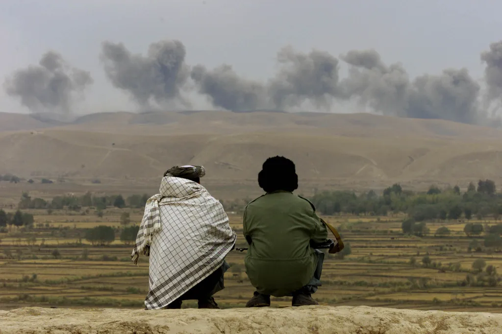 Dva vojáci sledují výbuchy na pozicích Talibanu na kopci Kalakata, poblíž vesnice Ai-Khanum v severním Afghánistánu, 1. listopadu 2001