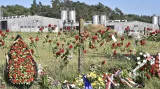 Aktivisté požadující odstranění vepřína donesli k památníku obětí romského holokaustu v Letech u Písku květiny. Vyfoceno 24. 6. 2017