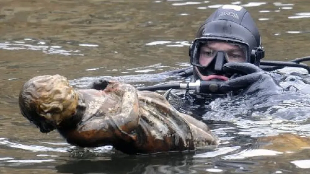 Potápěč vyzdvihuje sochu andělíčka