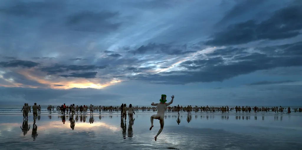 Účastníci každoročního běhu North East Skinny Dip na pobřeží britského zálivu Druridge Bay