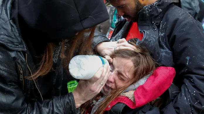 Demonstrantka zasažená pepřovým sprejem během protestů proti inauguraci Donalda Trumpa
