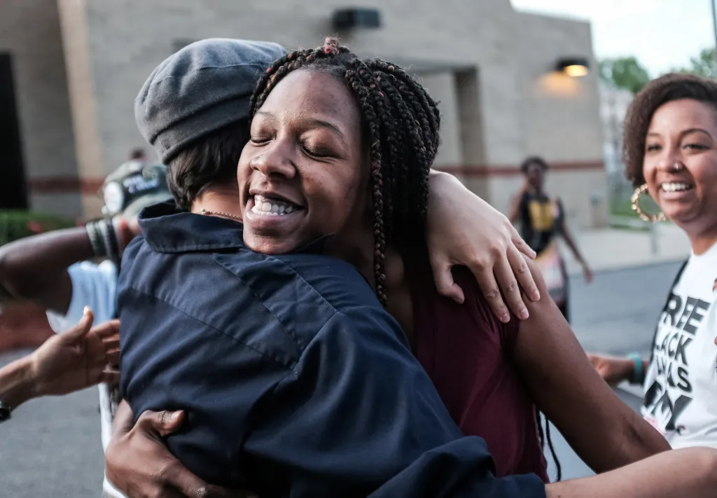 Američanka Cheyenne Brewingtonová se objímá s dobrovolníky z hnutí Free Black Mamas DMV. Členové této organizace zveřejnili důkazy, které vedly k jejímu propuštění z vězení. Důvodem uvěznění byla půjčka ve výši 1500 dolarů, kterou nemohla žena ze sociálních důvodů splatit