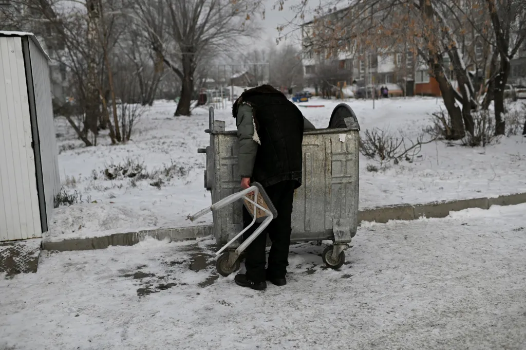 Zrakově postižený bezdomovec Bystruškyn prohledává popelnici