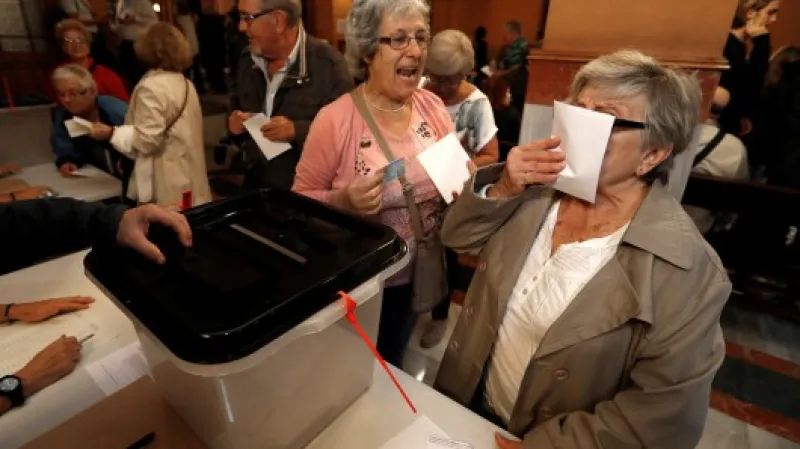 Žena líbá volební lístek před odevzdáním svého hlasu do urny v Barceloně,  Autor: Yves Herman,  Zdroj: Reuters