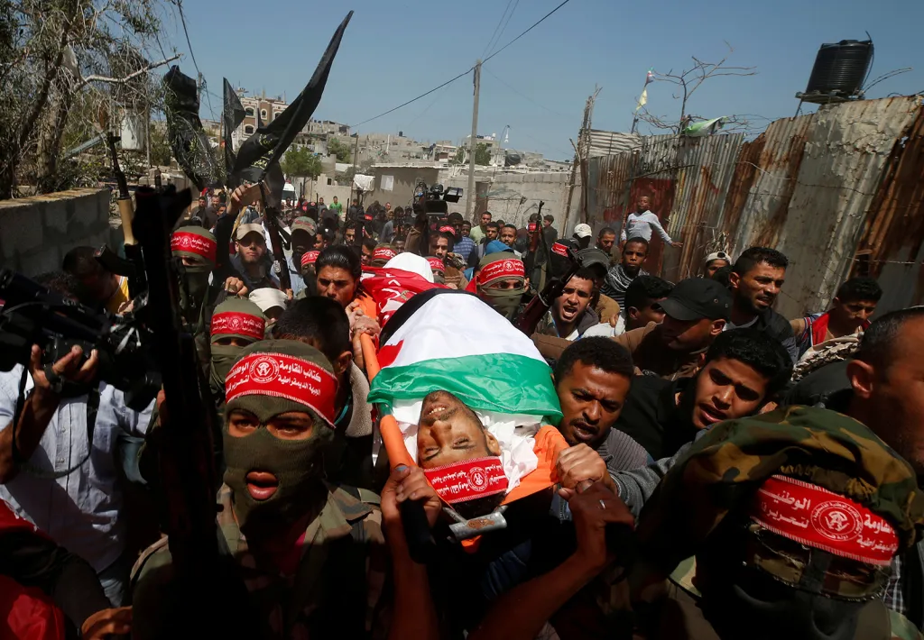 Militantní Palestinci odnášejí tělo zabitého Ahmeda Arafaha (25) při protestech na hranicích Izraele a pásma Gazy