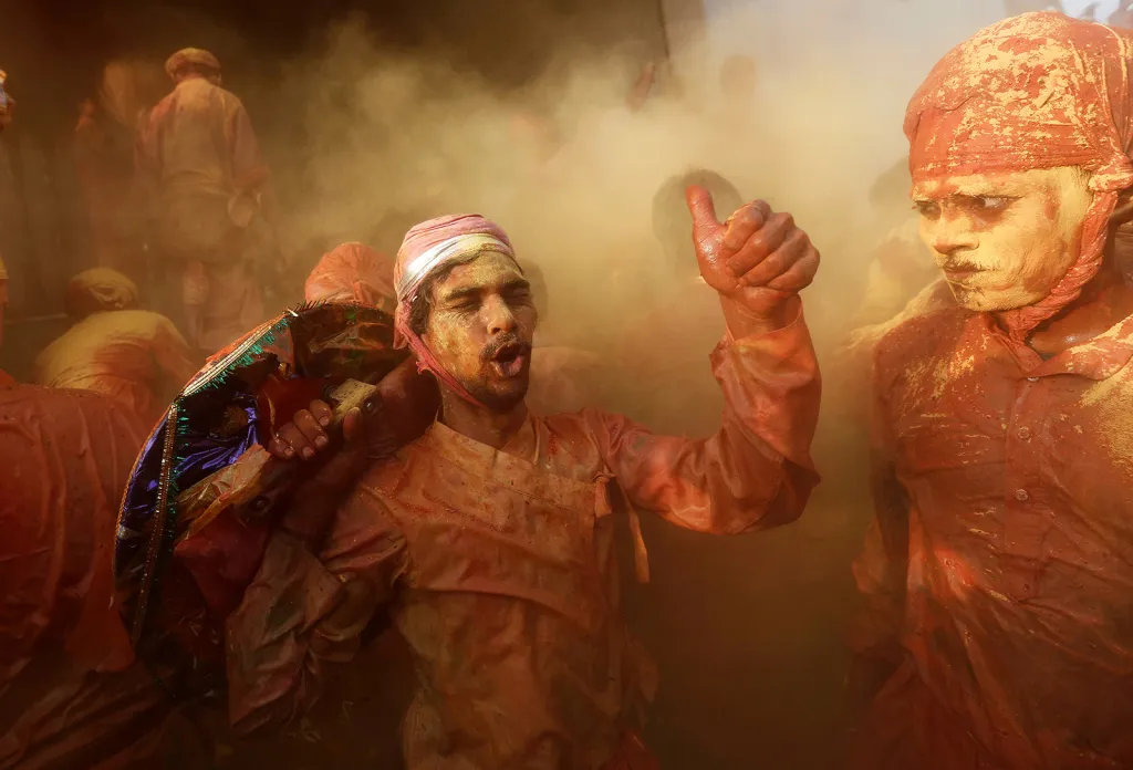 Hinduisté během náboženského svátku Holi uvnitř chrámu ve vesnici Nandgaon, v indickém státě Uttarpradéš