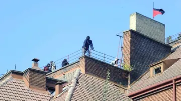 Squatteři na střeše domu v Apolinářské