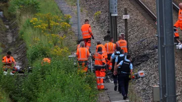 Pracovníci SNCF a policie na místě žhářského útoku