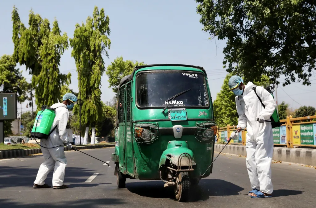 Tuk-tuk je v Indii typickým dopravním prostředkem. Na snímku tento druh taxi prochází dezinfekcí
