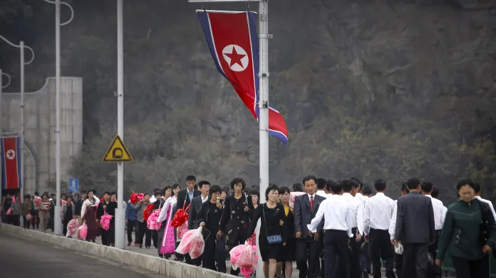 Na slavnost na náměstí Kim Ir-sena přicházely davy lidí s plastovými květinami