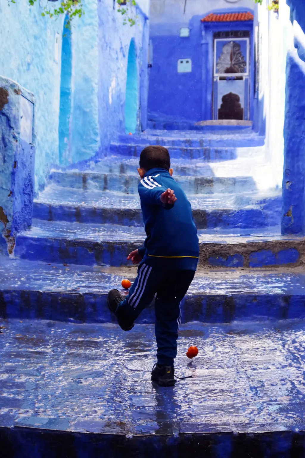 Fotografie vítězky mládežnické kategorie Isabelly Smithové (14 let): Chefchaouen, Maroko. „Tenhle moment mě opravdu zaujal. Obraz dítěte hrajícího si s pomerančem jako s balonem byl přesným opakem toho, co jsem zvyklá vídat ve své zemi, kde si děti hrají s drahými hračkami.“