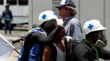 Záchranáři pomáhají zraněným při střetech mezi opozičními demonstranty a bezpečnostními silami v blízkosti letecké základny Generalisimo Francisco de Miranda "La Carlota" v Caracasu