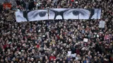 Při útoku bylo zastřeleno 10 novinářů a dva policisté. Snímek z tzv. průvodu jednoty, kterého se v Paříži zúčastnily statisíce lidí a vrcholní politici EU i arabského světa, ukazuje transparent s očima zastřeleného šéfredaktora Stephana Charbonniera.