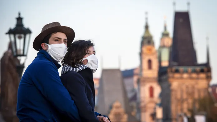 Mladá dvojice s rouškami na Karlově mostě v Praze