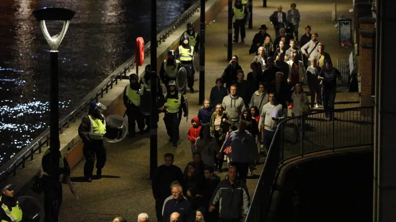 Policie odvádí lidi do bezpečí