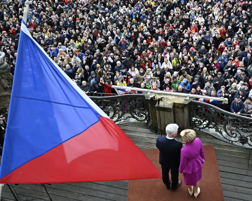 Prezident Petr Pavel a první dáma Eva Pavlová zdraví přihlížející z balkonu na třetím hradním nádvoří
