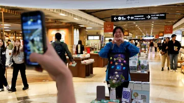 Jihokorejci se fotí s knihami Han Kang v soulském knihkupectví