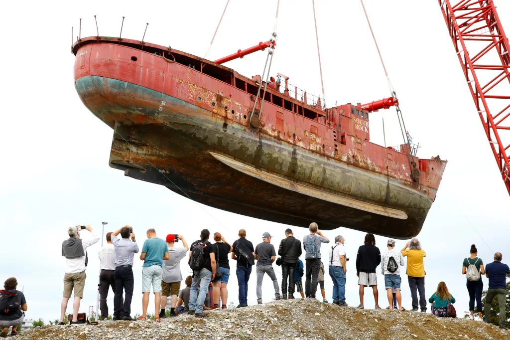 Diváci sledují vyzvedávání britské majákové lodi Gannet, jež byla postavena v roce 1954, z řeky Rýn v Basileji ve Švýcarsku