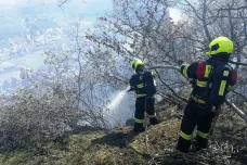 U Prahy hoří les na skále. Hasiči nasadili vrtulník, k požáru museli i slaňovat