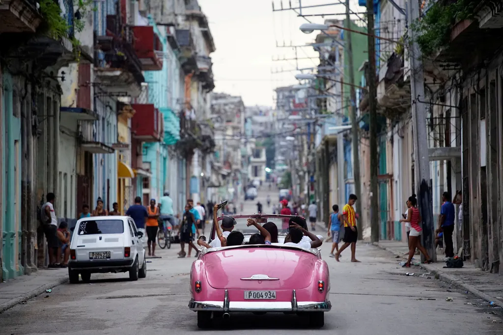 Turisté při vyjížďce v americkém veteránu v ulicích Havany