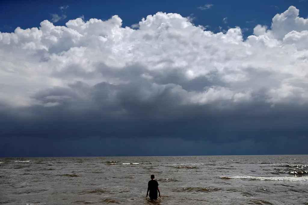 Patnáctiletý Jordan Carambat se brouzdá na okraji oceánu ve chvíli, kdy se k pobřeží státu Mississippi blíží tropická bouře Gordon