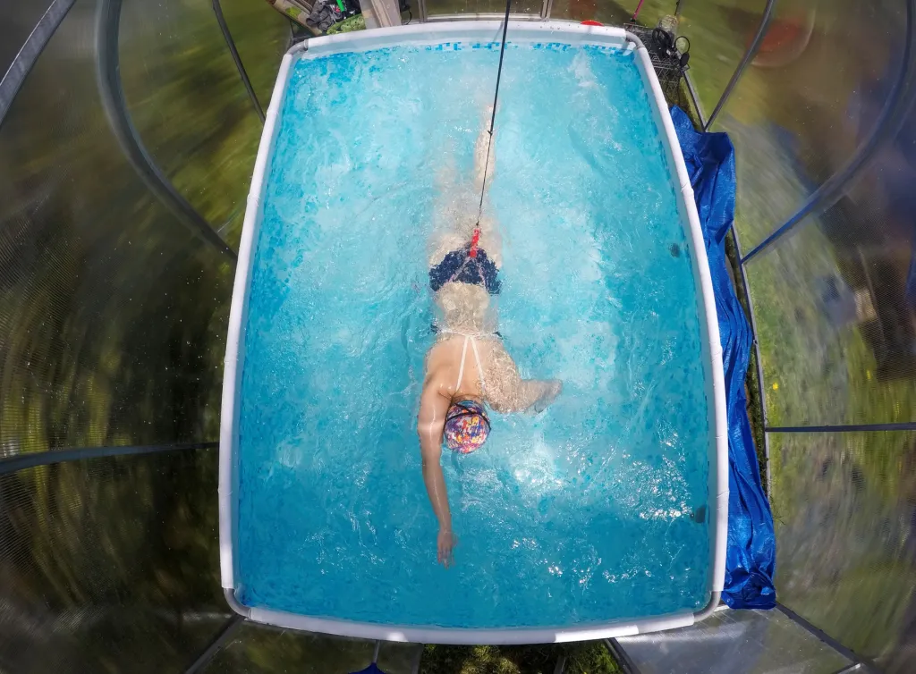 Ruská plavkyně trénuje na závody v bazénu své kamarádky ve skleníku na zahradě. Důvodem je uzavření velkých sportovišť kvůli možné nákaze onemocněním covid-19