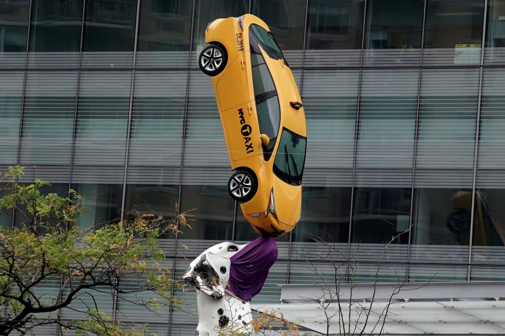 Socha dalmatina, který na čenichu balancuje s vozem taxislužby, dostala roušku. Odkazuje tak i na ekonomické problémy, které pandemie způsobuje profesionálním řidičům. Dílo je umístěno přímo na Manhattanu v New Yorku