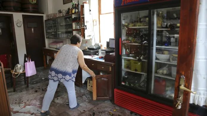 Žena uklízí svůj obchůdek po zemětřesení v Plomari