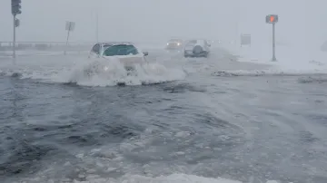 Řidiči prodírající se se svými vozy zaplavenou ulicí Beach Road poté, co hladina oceánu překročila bezpečnostní stěnu během zimní bouře na předměstí Bostonu v americkém státě Massachusetts.