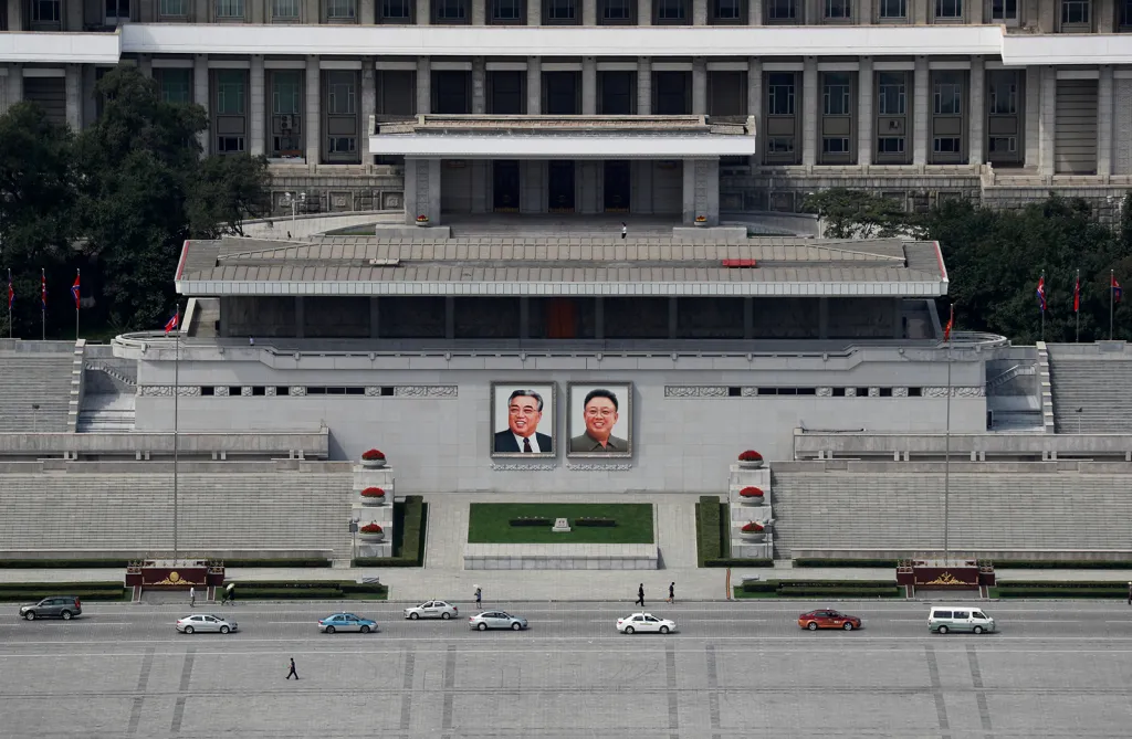 Severokorejská doprava míjí nadživotní portréty dvou zesnulých vůdců Kim Ir-sena a Kim Čong-ila na náměstí Kim Ir-sena v Pchjongjangu