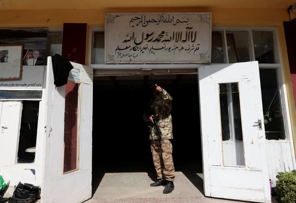 Voják z Talibanu hlídá vchod do školy v hlavním městě Kábulu