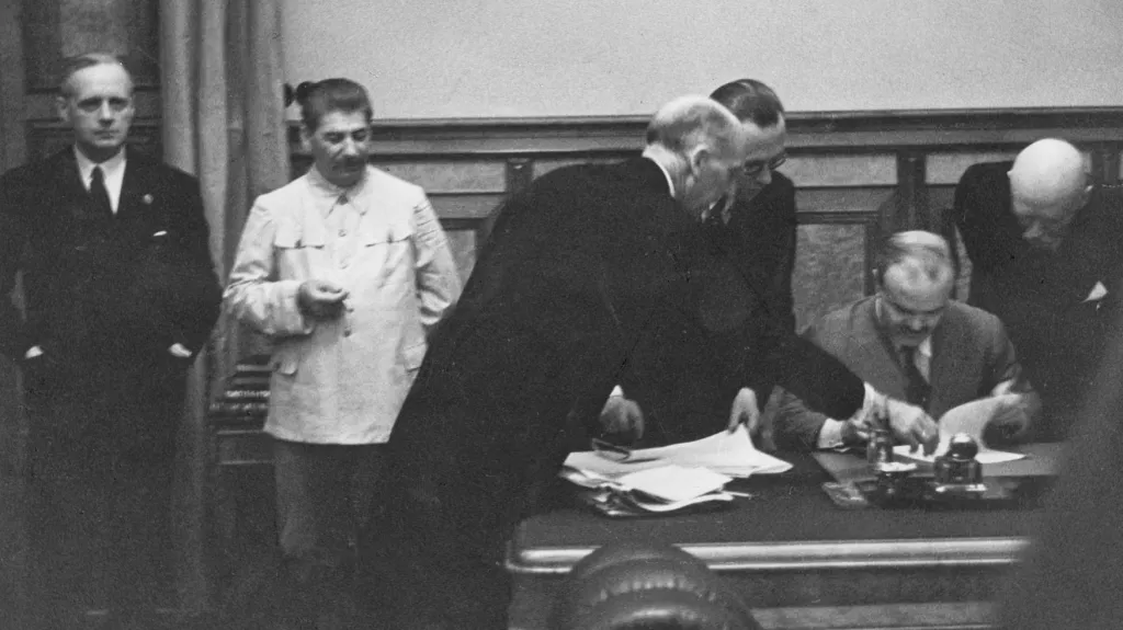 Vjačeslav Molotov podepisuje v Kremlu smlouvu s Německem. Vlevo na snímku německý ministr zahraničí Joachim von Ribbentrop a Josif Stalin